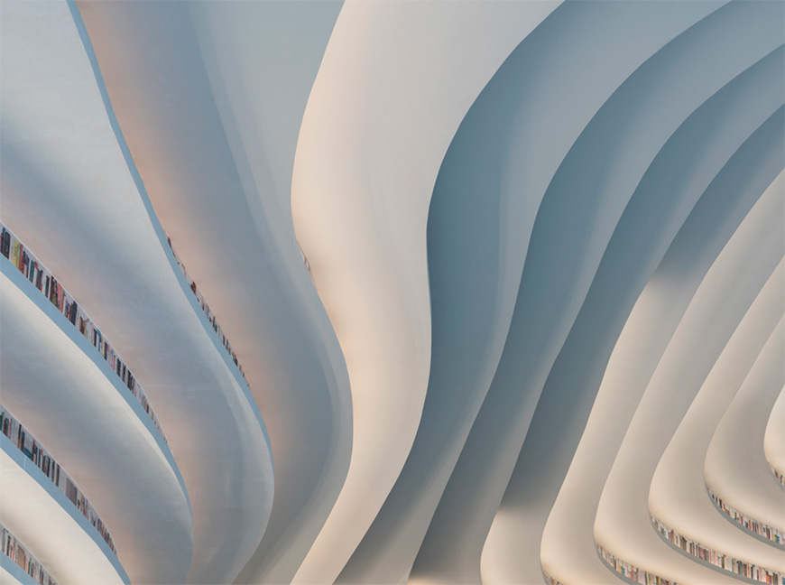 The futuristic library sits within a sheltered gallery, topped with cathedral-like vaulted arches, which winds its way throughout the scheme. library binhai 04